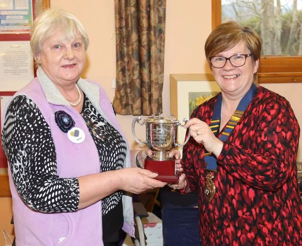 Stewartry SWI Lesley Malcolmson president hands over the Cunningham Trophy to Annie Kelly from Crocketford